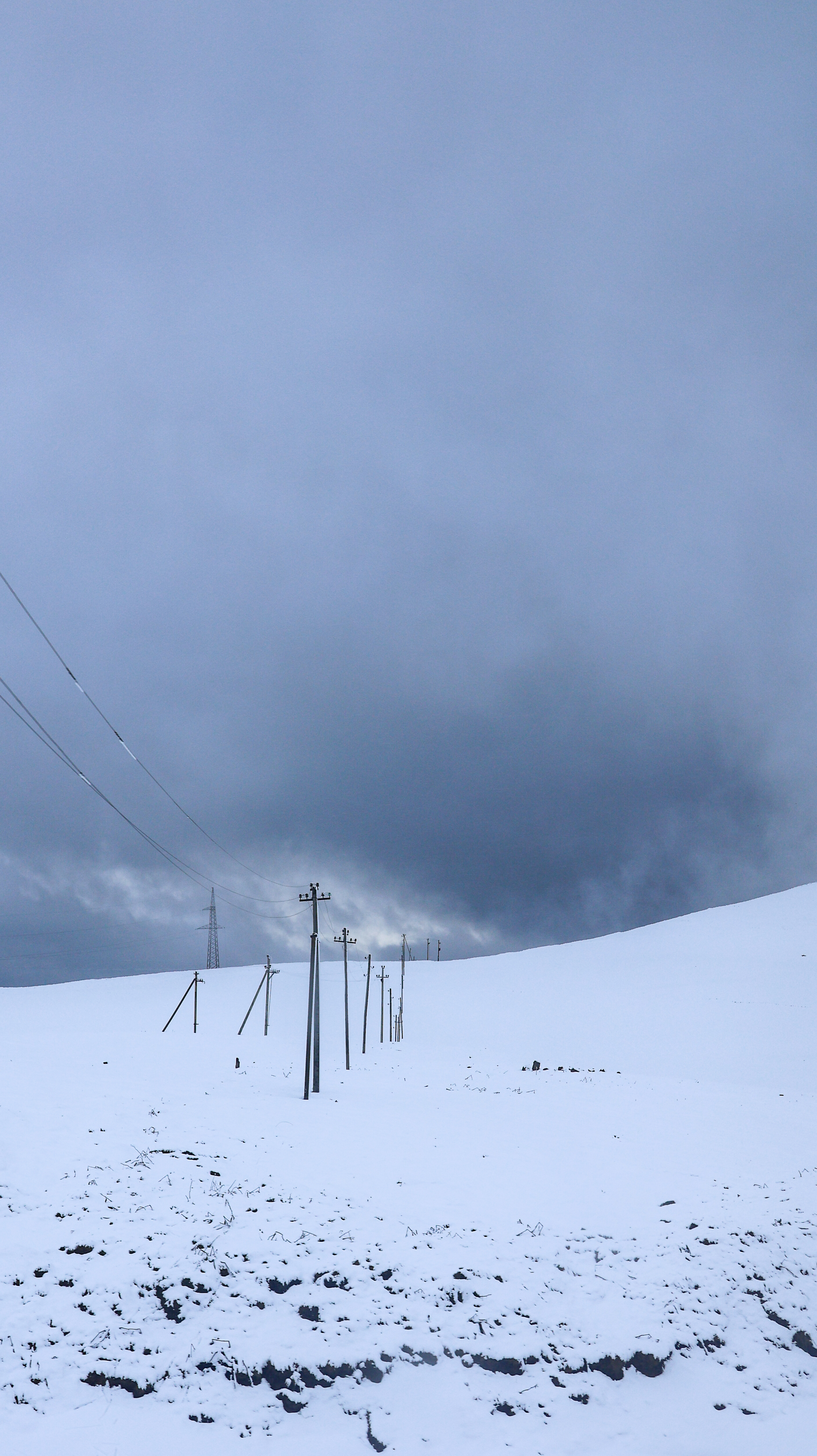 Telegraph poles across a snow-covered hillside, Georgia