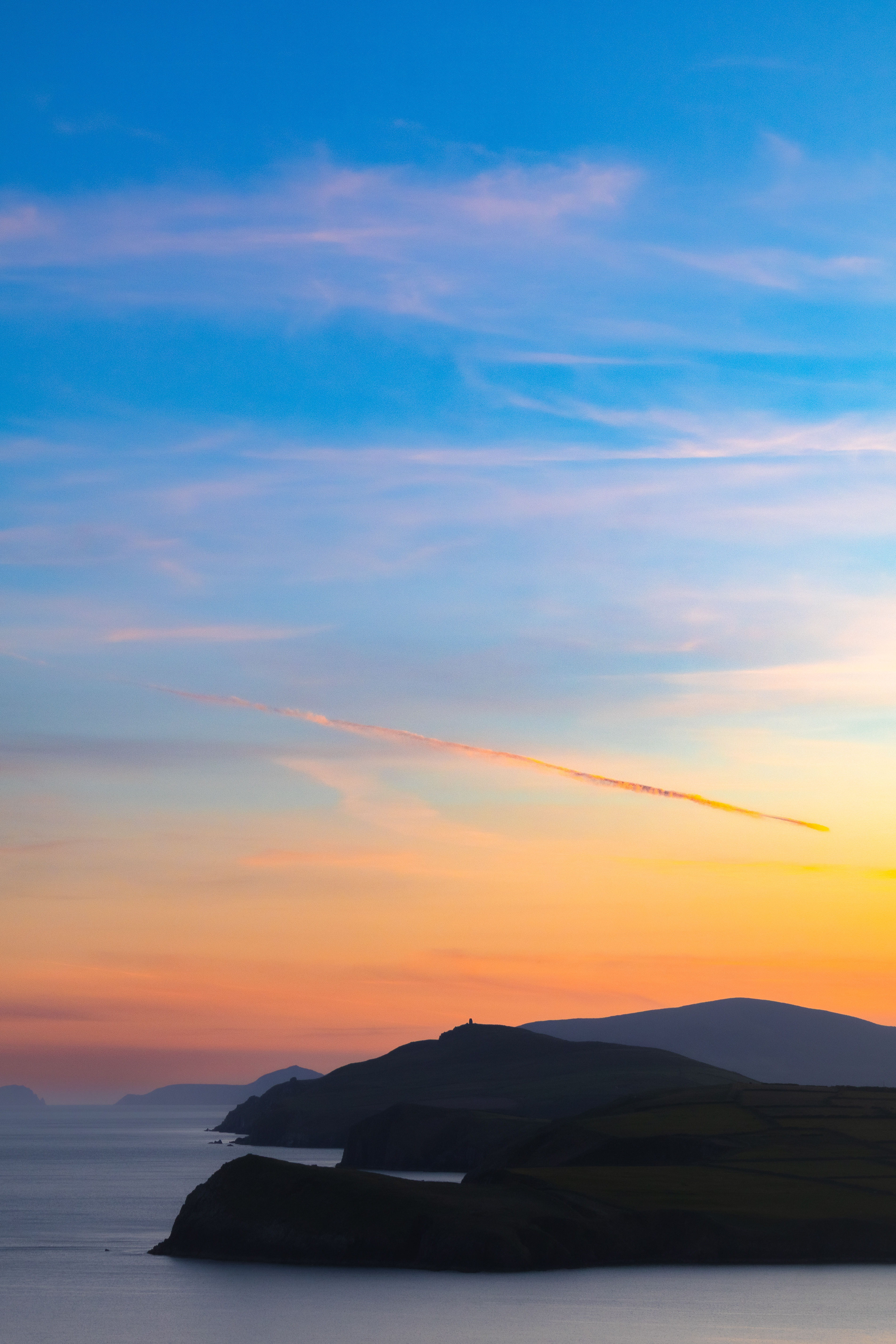 Coastal sunset, silhouetted cliffs, Ireland